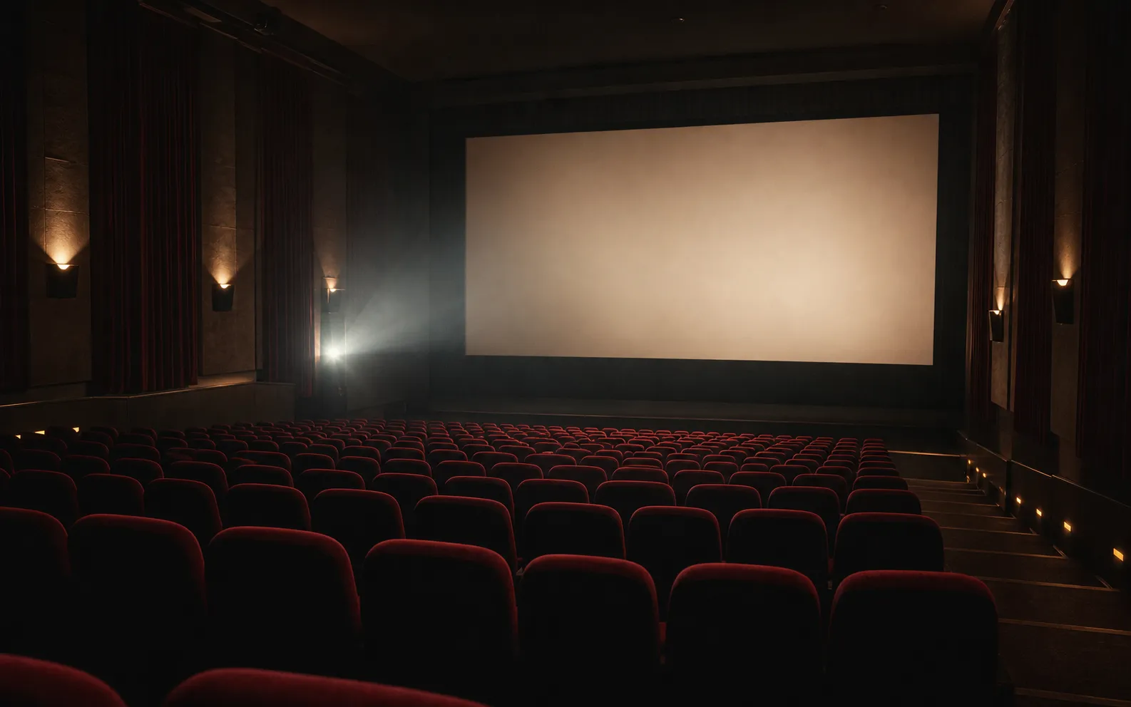 An empty cinema auditorium with burgundy seats facing a softly lit screen